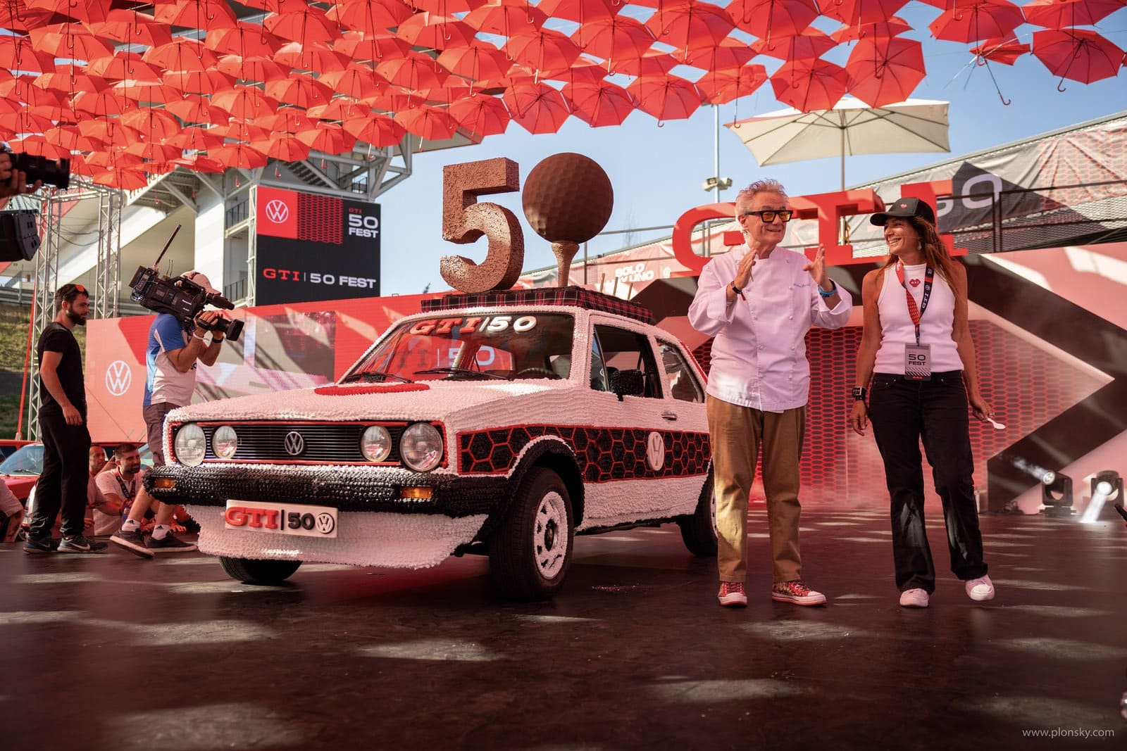 La tarta-escultura del aniversario y el entorno GTI construyen un
momento ritual con lectura inmediata de los 50 años.